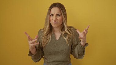 Hüsrana uğramış bir suratı olan çekici sarışın bir kadın sarı arka plan duvarında izole edilmiş..