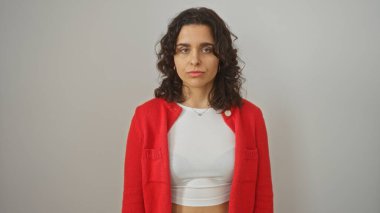 Young, attractive hispanic woman with brunette hair posing over an isolated white background in a red sweater and a white top. clipart