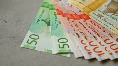 Norveç banknotları, finansal kavramları temsil eden renkli elli bin kron banknotlar içeren beton bir yüzey boyunca yayıldı.