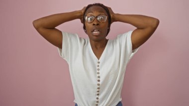 İzole edilmiş pembe arka planda kafasını şaşırtan kadın, duygularını ifade eden vücut diliyle aktarıyor.