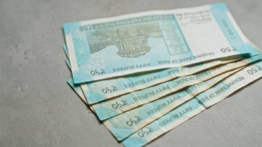 Hindistan 'da mali işlemleri, tasarrufları ve ekonomiyi gösteren somut bir yüzeyde gösterilen 50 rupilik Hint banknotları.