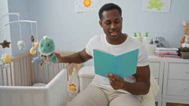 Adam beşikteki bebeğe kitap okuyor, oyuncaklarla çevrili ve rahat yatak odasında, yumuşak renkler ve yumuşak mobilyalarla sıcak ve rahatlatıcı bir ev atmosferi yaratıyor..