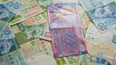 Hong Kong dolar banknotları çeşitli banknotlar bir yüzeye yakın bir görüntüde dağınık, renkli para birimi ayrıntıları sergileniyor.