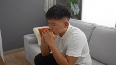 Genç adam, gün boyunca, derin düşünceler içinde, evinin oturma odasında oturuyor..