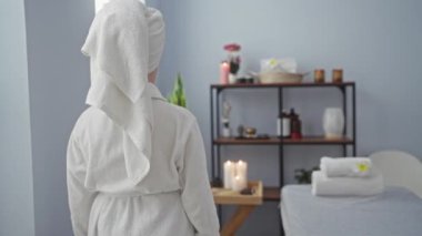 Rahatlatıcı spa ortamında gülümseyen bir kadın, güzel dekore edilmiş bir iç mekan, mumlar ve rahat havlular, refah ve kişisel bakım temaları için ideal..