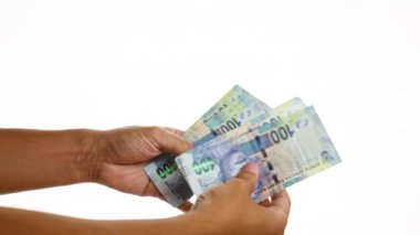 İzole edilmiş beyaz bir arkaplan karşısında Güney Afrika Rand para birimleri el ele tutuşup sayıyor.