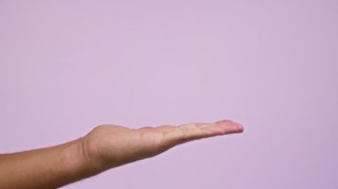 Açık pembe arkaplan üzerinde uzanan eli işaret eden adam etkileşim veya talimat öneriyor