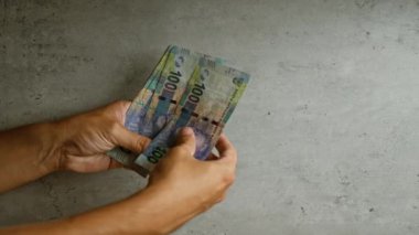 Gündelik hayatta para, finans ve uluslararası değişimleri vurgulayan somut geçmişe sahip Güney Afrikalı randaları sayan bir adam.