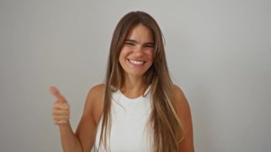 Genç, güzel, İspanyol bir kadın, izole edilmiş, beyaz bir arka plana bakıp gülümsüyor.