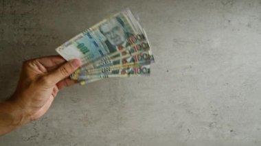 Peru tabanlarını beton bir zemine dayayıp çeşitli banknotlar sergiliyorlar..