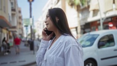 Şehir caddesinde telefonla konuşan bir kadın.