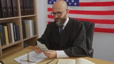 Yargıç, arka planda ABD bayrağı varken ofiste dolar sayıyor.