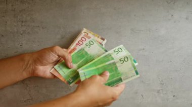 Norveç kronu banknotlarını tutan eller, Norveç 'in para birimini vurguluyor.