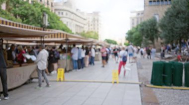 Barselona, İspanya 'daki canlı bir açık hava vintage pazarını keşfeden insanların Avrupa' da bir sokak ortamında ikinci el tezgahlar sergilediği bulanık bir manzara.
