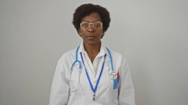 Orta yaşlı, kıvırcık saçlı, steteskop ve gözlüklü, izole edilmiş beyaz arka planda duran Amerikalı kadın doktor..