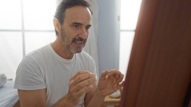 Kaplıca ortamında orta yaşlı bir adam evde kendine bakmakla meşgul. Sağlık ve rahatlama odağı gösteriyor..