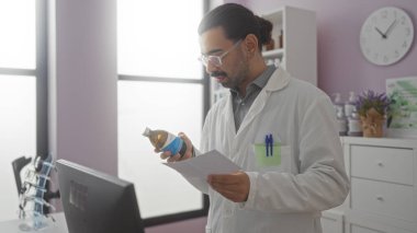 Eczacı eczane ortamında ilaç ve reçeteyi inceliyor. Beyaz laboratuvar önlüklü, elinde şişe ve kağıt olan İspanyol bir adam var.