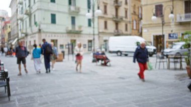 Bulanık insanlar ve Bokeh binalarının bulunduğu La Spezia 'daki sokak manzarası, Avrupa' nın tarihi şehrinde güneşli bir günün tadını çıkaran aylaklarla canlı bir şehir atmosferi yakalıyor..