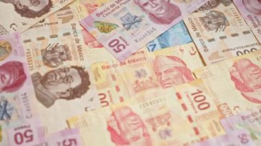 Meksika 'nın farklı banknotları bir masaya saçılmış, canlı renkler ve Meksika' nın para birimini temsil eden detaylı tasarımlar sergiliyor..