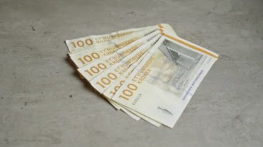 Danimarka 100 kron banknotları beton bir yüzeye yayılarak Danimarka 'nın ulusal para birimini gözler önüne serdi..