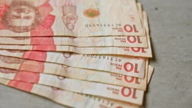 Kolombiya banknotları beton bir yüzeye yerleştirilmiş. Hayran olunan bir düzende 10.000 peso görünüyor..