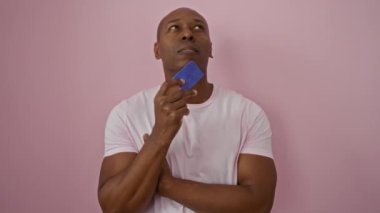 Pembe arka planda mavi kart tutan, beyaz gömlek giyen ve düşünceli görünen bir adam görülmemiş bir seyirciyle ilişki kurarken davetkar bir ifade sunuyor..