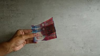 El ele tutuşan Hong Kong doları banknotları kentsel bir finansal konsepti temsil eden somut bir geçmişe karşı.