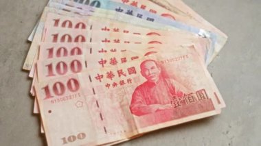 Çin Yuan banknotları, önemli tarihsel figürleri ve karmaşık tasarımları tasvir eden çeşitli mezheplerin sergilendiği beton bir yüzeye yayıldı.