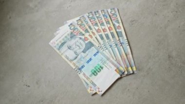 Peru 'da 100 taban para içeren beton bir yüzey üzerine yayılmış Peru banknotları.