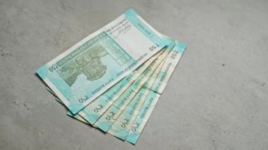 Hindistan bankalarında 50 rupi yer alan beton yüzeyde Hindistan 'dan fan benzeri bir şekilde düzenlenmiş para sergileniyor..