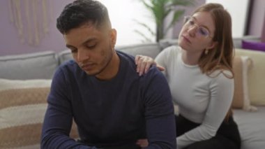 Kapalı bir koltukta oturan çift, modern bir oturma odasında sevgi ve bağın altını çizen hassas bir anı paylaşıyor..