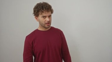 Gösterideki şüphecilik, tişörtlü genç İspanyol adam ağzı açık şüpheli bir bakış izole edilmiş beyaz arka planda alaycı bir ifade.