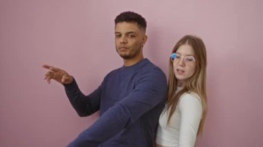 Pembe bir duvarın önünde dans eden çift, neşeli ve sevgi dolu bir atmosferde neşeli bir anın tadını çıkaran gülümseyen bir adamla bir kadının yer aldığı..