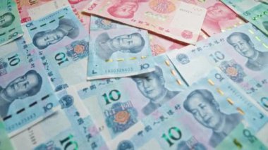 Çin Yuan banknotları düz bir yüzeye yayılarak Çin 'den gelen renkli tasarımı ve çeşitli değerleri vurguladı.