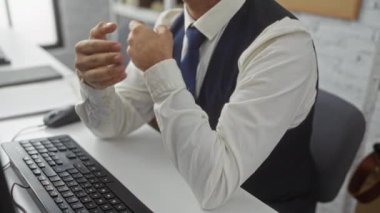 Genç adam bir ofis ortamında çalışıyor, elleri klavyenin üzerinde hareket ediyor, iş ortamında iletişim ve etkileşim kuruyor..