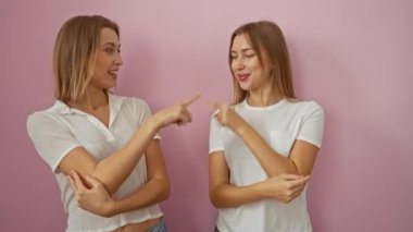 Pembe bir duvara karşı neşeli tebessümlerle birbirlerini işaret eden kadınlar, kardeşçe bir bağ ve neşeli aile etkileşimi sergiliyorlar..