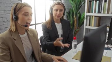 Kadın meslektaşlar ofiste başarıyı kulaklıklarla kutluyorlar..