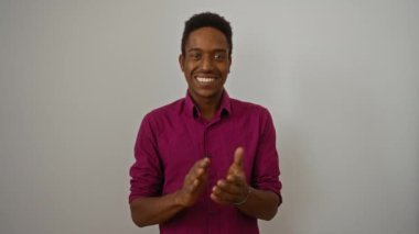 İzole edilmiş beyaz arka planda alkışlayan genç bir adam pozitif enerji ve karizma sergiliyor canlı pembe gömlekli modern moda tarzını sergiliyor..