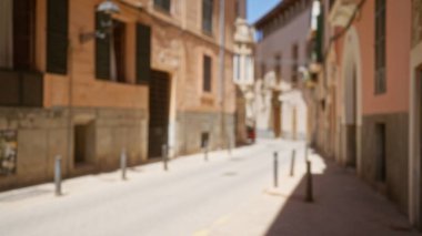 Güneşli bir günde İspanyol mimarisini sergileyen eski binalarla Mallorca 'daki bulanık sokak manzarası