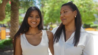 Anne ve kızı şehir parkında ailecek vakit geçiriyorlar. Güneşli bir günde bağlarını ve dostluklarını gösteriyorlar..