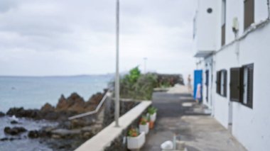 Lanzarote 'daki bulanık hava manzarası. Odakları kesilmiş insanlar, beyaz binalar ve kanarya adalarındaki okyanus manzarası, İspanya.