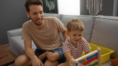 Baba ve oğul oturma odasında bir abaküs ile oynuyorlar. Ev ortamlarında aile bağlarını ve sevgiyi paylaşıyorlar. Ebeveynlik ve çocukluk ilişkilerini kapalı alanlarda gösteriyorlar..
