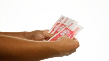 İzlanda Krona banknotları tutan eller izole edilmiş beyaz bir arkaplanda.