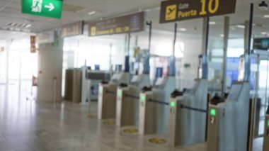 Bulanık havaalanı terminali. Kapıları ve bulanık tabelaları seyahat kontrol noktaları ve güvenlik bölgelerini gösteriyor.