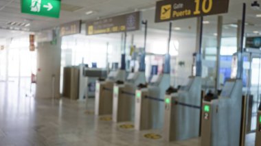 Blurred airport terminal with defocused gates and blurry signage indicating travel checkpoints and security areas clipart