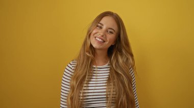 Young beautiful blonde woman smiling against isolated yellow wall background clipart