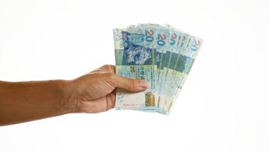İzole edilmiş beyaz bir arka planda birden fazla Hong Kong doları tutuyor.