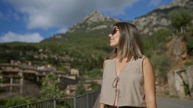 Deia, Mallorca, İspanya, açık havada manzaranın tadını çıkaran genç bir kadın güneşli bir ada gününde dinleniyor.