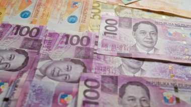 Filipin banknotları dağınık, çeşitli pezo değerleri sergileniyor