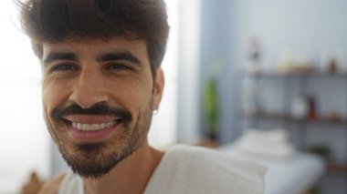 Kaplıcada gülümseyen sakallı yakışıklı, genç bir İspanyol.